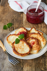 Fritters with raspberry jam on a white plate