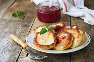 Fritters with raspberry jam on a white plate