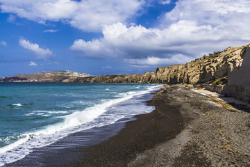Fototapeta na wymiar The black beach is surrounded by rocks