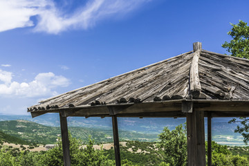 The roof of a wooden gazebo in the mountains