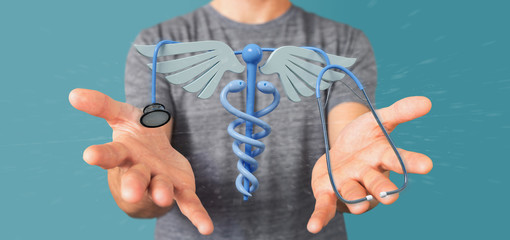 Fototapeta premium Businessman holding a 3d redering medical cadaceus and stethoscope