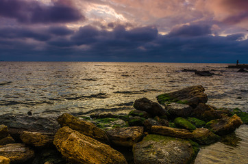 Fototapeta na wymiar Sunset on the sea beach with stones