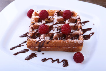 White plate with homemade belgian waffles with Sifting sugar powder over black background.