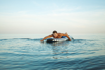 Man doing paddle surf at sunrise