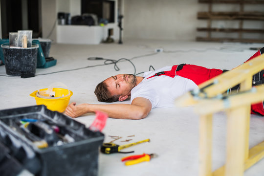 A man worker lying on the floor after an accident at the construction site.