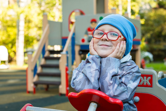 A child dressed in red glasses shows emotions