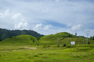 Obraz premium Beautiful Grass Mountain with Clear Blue Sky and Clouds