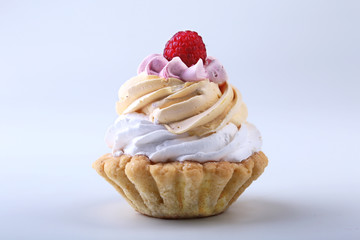 Tasty Homemade cupcake, muffin with cream and raspberry. Close up view delicious sweet dessert isolated on white.