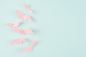 Halloween concept art of cut paper - pink soar bats on candy mint blue background, copy space.