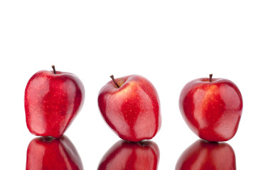 Three red apples on a white mirror background with reflection isolated close up