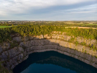 (Luftaufnahme, Drohne) Panorama mit blauem Kratersee im Steinbruch im Vordergrund