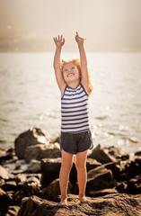 Fototapeta na wymiar Little girl with raised hands