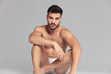 seated young man wearing only underwear is resting