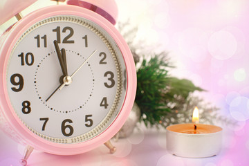 New Year atmosphere with a clock and a candle. Macro. New Year clock close-up. A festive candle and...