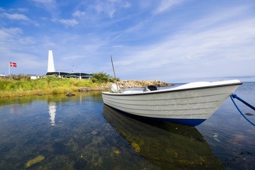 Fishing boat moored on the coast of Baltic Sea in Allinge, Bornholm, Denmark. Chimney of smokehouse...