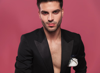 portrait of handsome young man wearing an undone black tuxedo