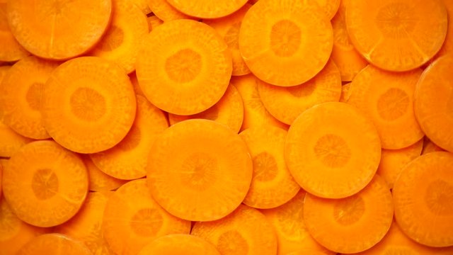 Carrots slices rotating, close-up, top view, 4K

