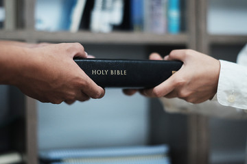 A woman is holding and hug the bible in the morning. Hands folded in prayer on a Holy Bible in...