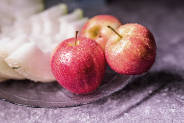 Apples and melon on a platter. Apples with water drops.