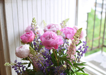 Peony and lupine bouquet closeup Wedding Birthday Summer flower White wooden background Copy space Lifestyle