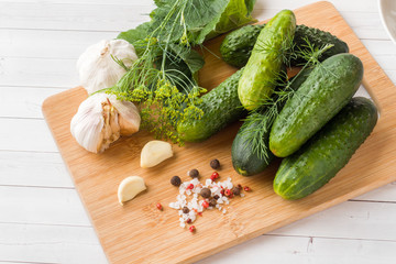 Marinated cucumbers, garlic and spices for salting on the wood surface.