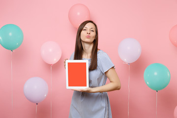 Portrait of pretty happy woman in blue dress hold tablet pc computer with blank empty screen...