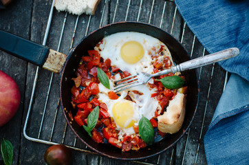 Shakshuka, Fried Eggs with Tomato Sauce in a Pan, Rustic Style and Wooden Background