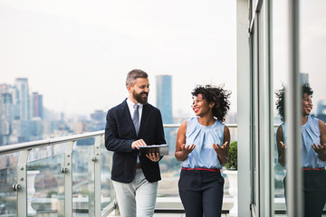 A portrait of two businesspeople standing against London view panorama.