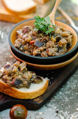 Traditional Caucasian saute from stewed eggplants, peppers, onions, tomatoes and herbs on the old background in rustic style