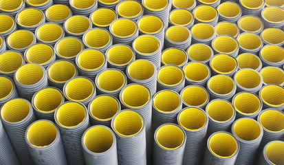 Stack of black  yellow corrugated plastic pipes