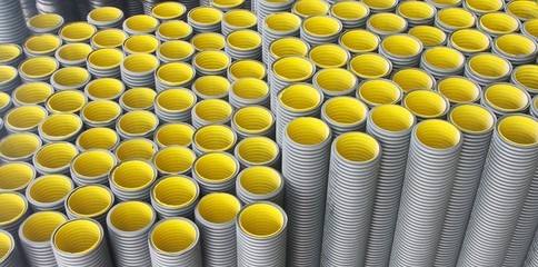 Stack of black  yellow corrugated plastic pipes