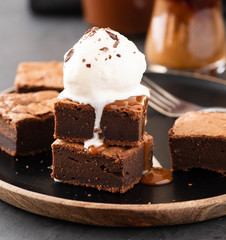 Chocolate brownies with salted caramel, vanilla ice cream. Copy space.