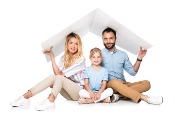 parents with daughter holding white roof over heads isolated on white, family insurance concept