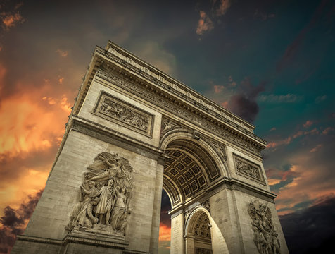 Arc de triumphal in Paris under sky with clouds. 