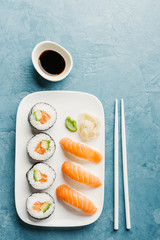 Sushi served on plate on blue table