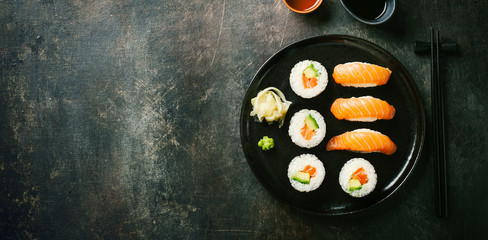 Sushi served on plate on dark table