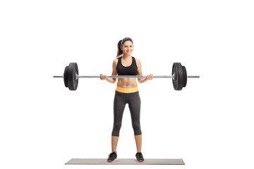 Young athletic female lifting a barbell