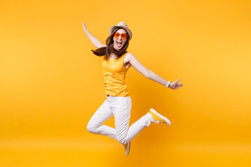 Portrait of excited smiling young jumping high woman in straw summer hat, orange glasses copy space...