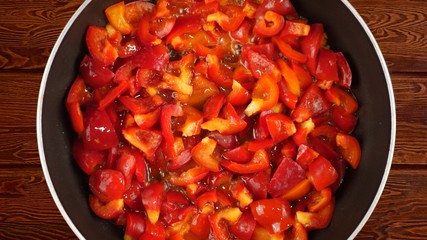 Cooking food concept. The cook fries a red sweet Bulgarian pepper in a frying pan.