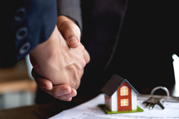 Real estate broker and customer shaking hands after signing a contract - Real estate, home loan and insurance concept