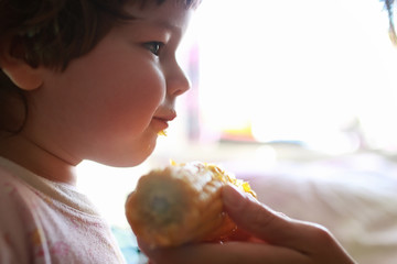 little boy eats greedily biting corn