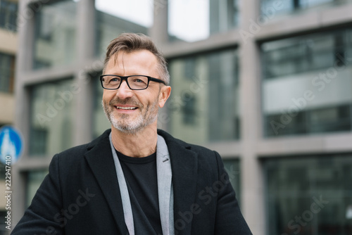 Smiling mature man against office building