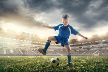 Young boy with soccer ball doing flying kick at stadium. football soccer players in motion on green grass background. Fit jumping boy in action, jump, movement at game. Collage