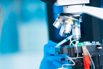technician girl with microfluidic device LOC in microbiological lab