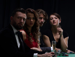 side view of group of people playing poker together in casino