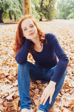 Pretty young woman relaxing in an fall park