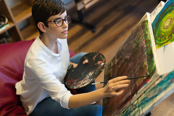 Creative pensive art school painter working on painting