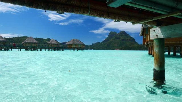 Luxury overwater villas on blue lagoon, white sandy beach and Otemanu mountain at Bora Bora island, Tahiti, French Polynesia
