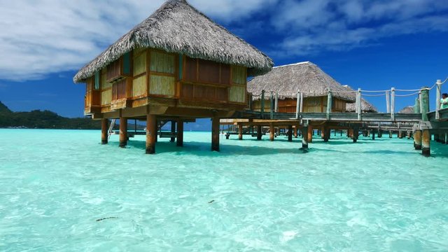 Luxury overwater villas on blue lagoon, white sandy beach and Otemanu mountain at Bora Bora island, Tahiti, French Polynesia
