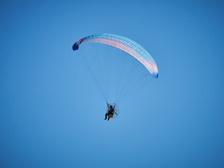 Powered paraglide or paramotor against blue sky. Paragliding
